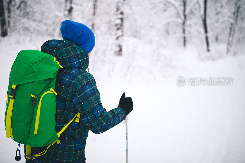 年轻人后视图独自行走雪山的旅行者。