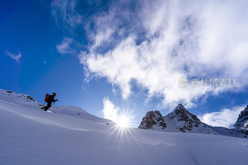 滑雪登山运动员攀登积雪的山脊线