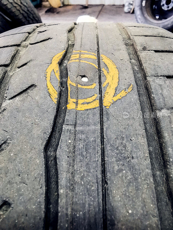 在汽车修理店标记的戳破汽车轮胎的特写