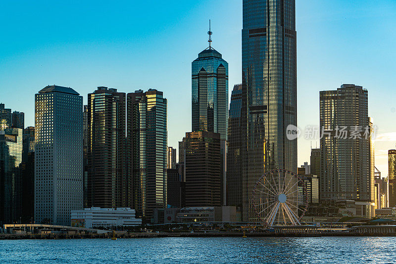 夕阳下的维多利亚港上空，可以看到香港市中心的摩天大楼。