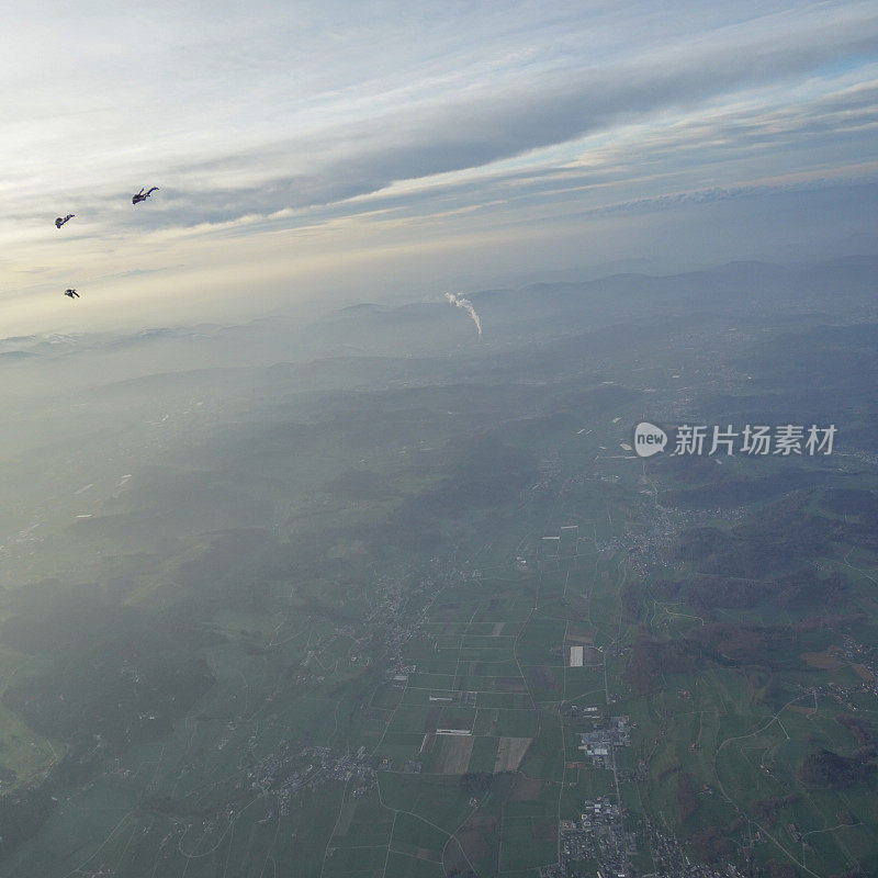 自由落体跳伞者在山景之上翱翔
