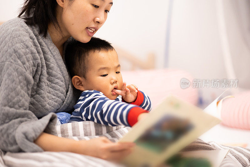 妈妈和小男孩在卧室里看书