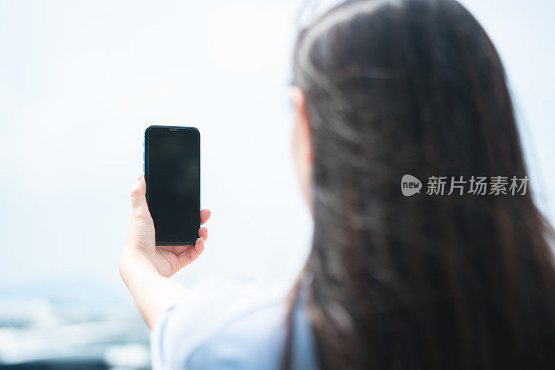 在户外使用智能手机的亚洲年轻女性