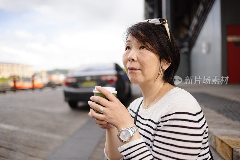 带着外卖咖啡在户外的女人