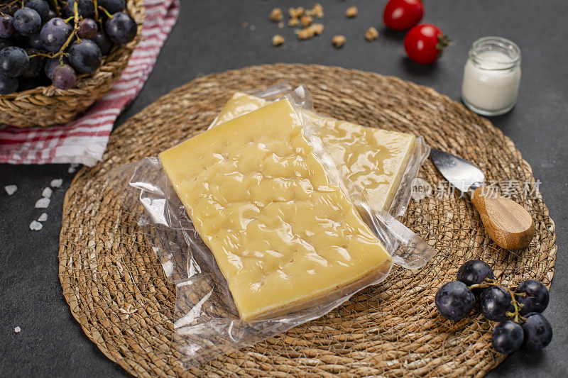 格鲁耶尔干酪放在木桌上，配上木砧板、刀和小道具