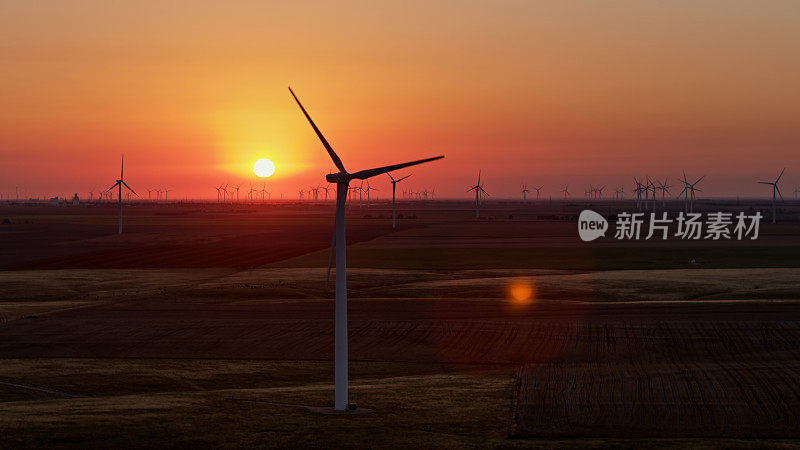 无人机拍摄的太阳出现在堪萨斯农场的风力涡轮机后面