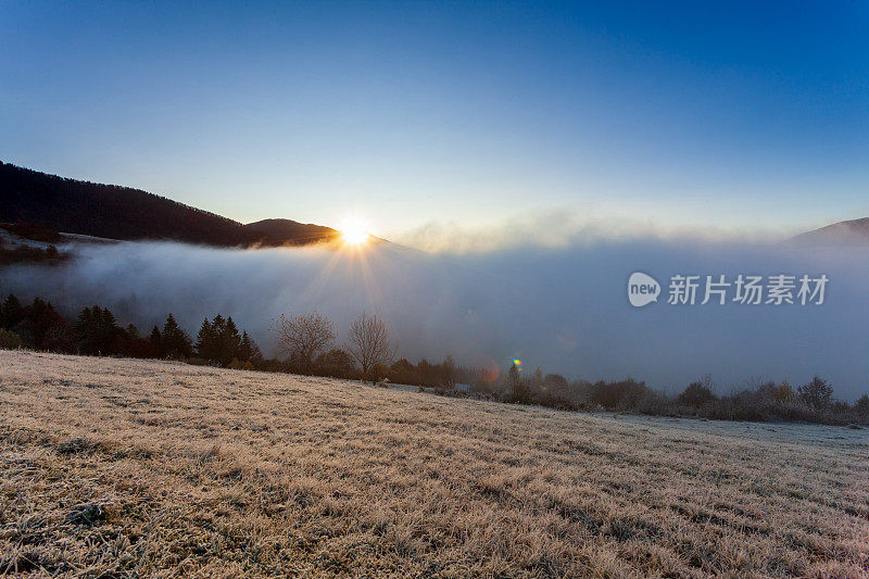 太阳从山后升起，雾在夏季清晨的黎明升起。清晨的雾消散在喀尔巴阡山脉。自然山水，自然风光，田园背景