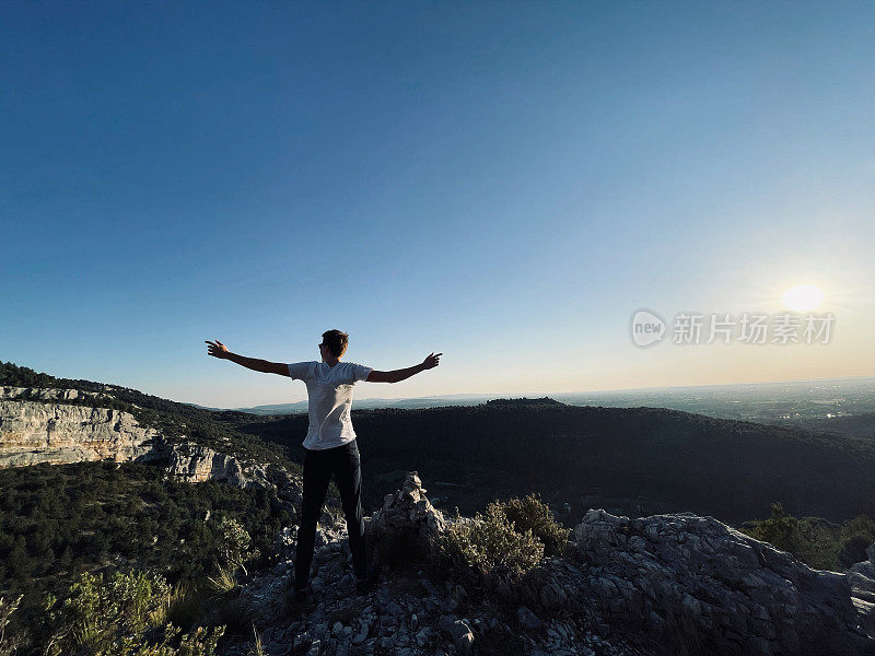 日出时分，徒步旅行者在阳光明媚的山脊上休息