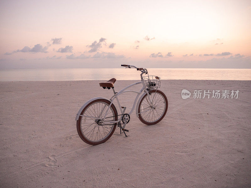 日落时在海滩上骑自行车