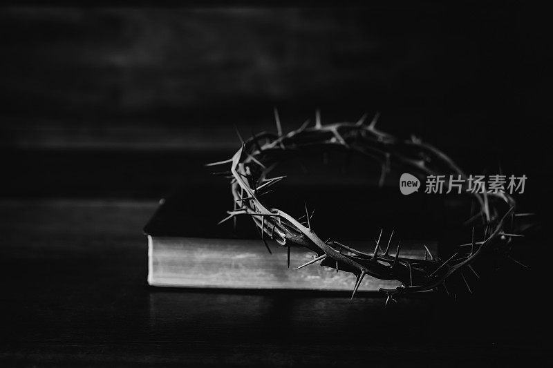 木桌上古老的圣经上方的耶稣基督受难像。