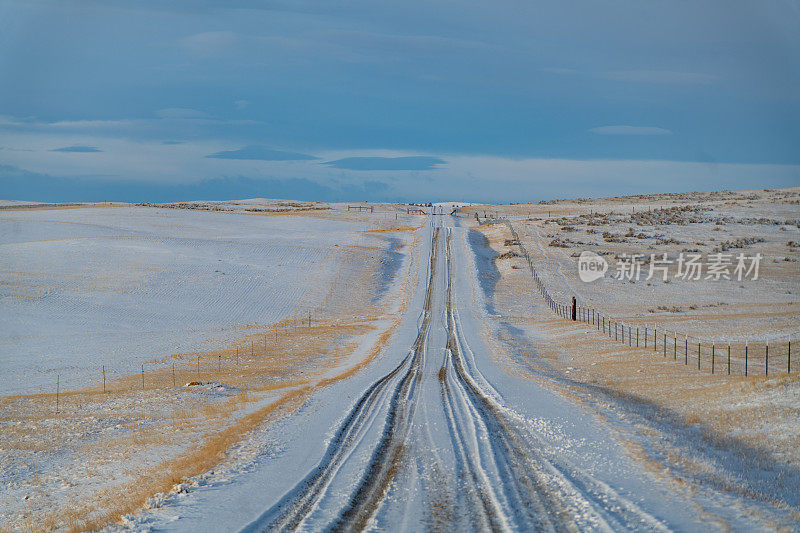 日落时分，蒙大拿山上的泥土路被白雪覆盖