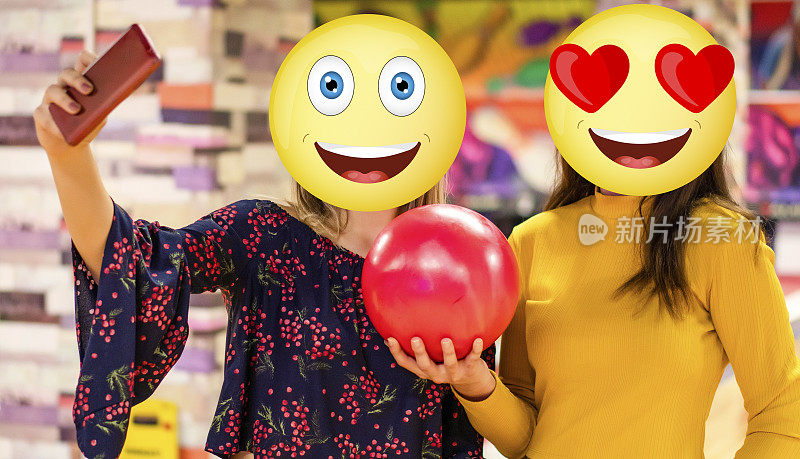 两个脸上有表情符号的女人的正面图片。微笑和可爱的微笑表情。他们在商店里自拍。保龄球，休闲游戏的理念。