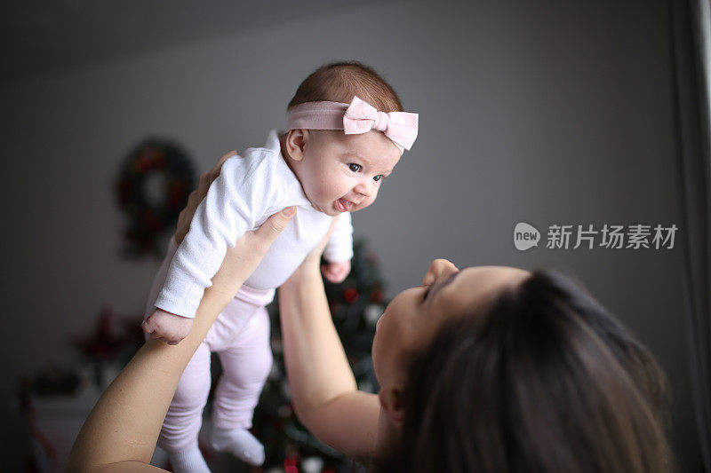 年轻的母亲，抱着她刚出生的女儿在客厅的照片