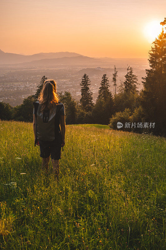 一名女性徒步旅行者在长满草的山脊上休息