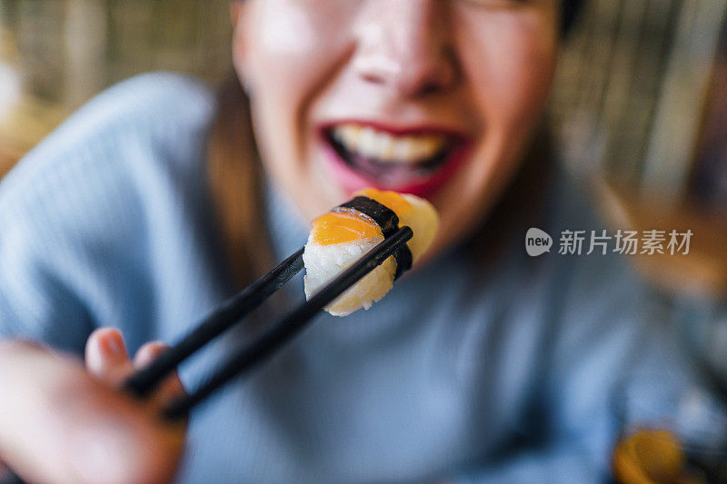 女人正在吃美味的三文鱼寿司