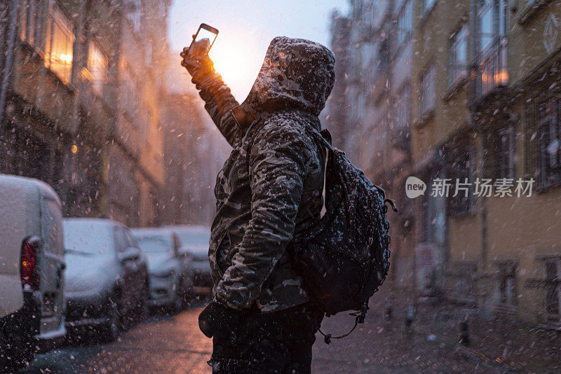 冬天，满脸胡须的中年男子在下雪的日子里在伊斯坦布尔街头的肖像。