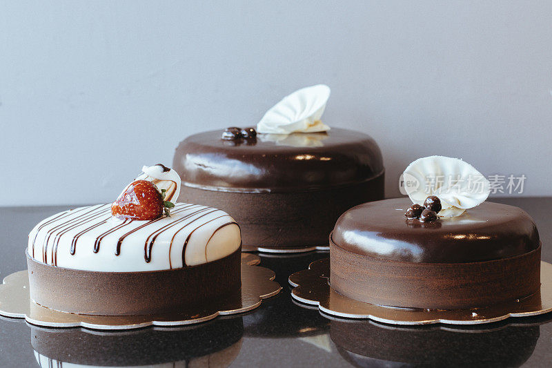 巧克力蛋糕顶部有一个草莓，巧克力蛋糕孤立在白色，三个巧克力蛋糕，黑森林蛋糕，圆形巧克力蛋糕，