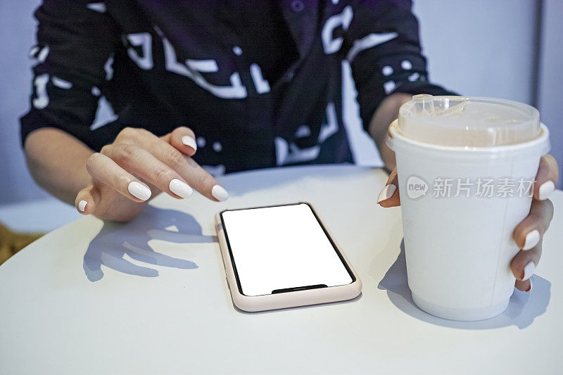 女人边喝咖啡边玩手机
