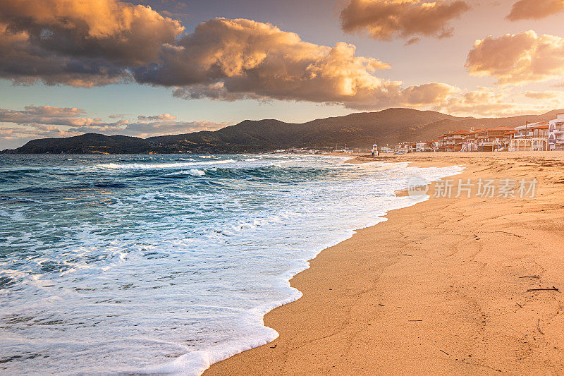 在日落时分，标志性的萨蒂度假小镇和著名的漫长而空旷的沙滩的壮观全景。在希腊哈尔基迪基度假