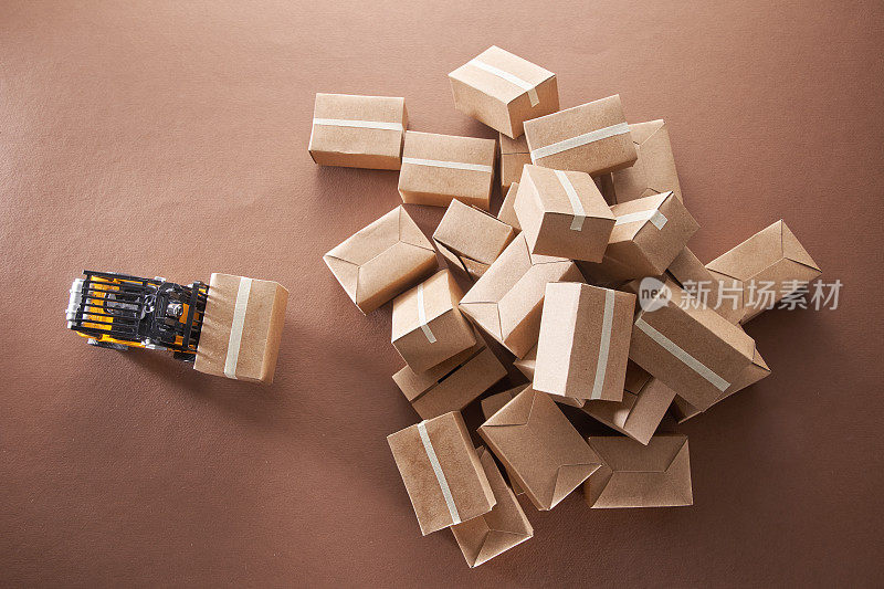 一堆棕色的纸板箱与玩具叉车准备交付。