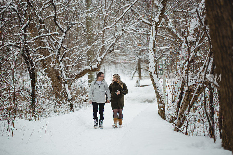 一对夫妇和一个孕妇在冬天散步的肖像