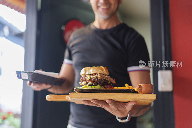 一家快餐店的厨师自豪地展示他们做的食物