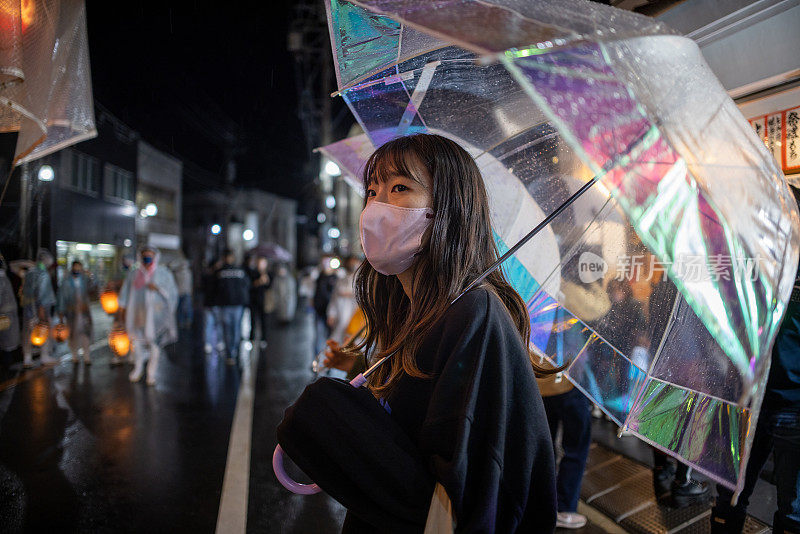 雨夜，年轻女子举着透明伞，观看祭祭表演