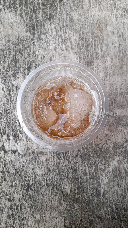 甜冰茶在玻璃顶视图与街道纹理背景。