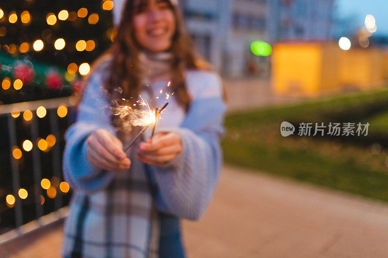 一个美丽的女人在户外拿着烟火的特写