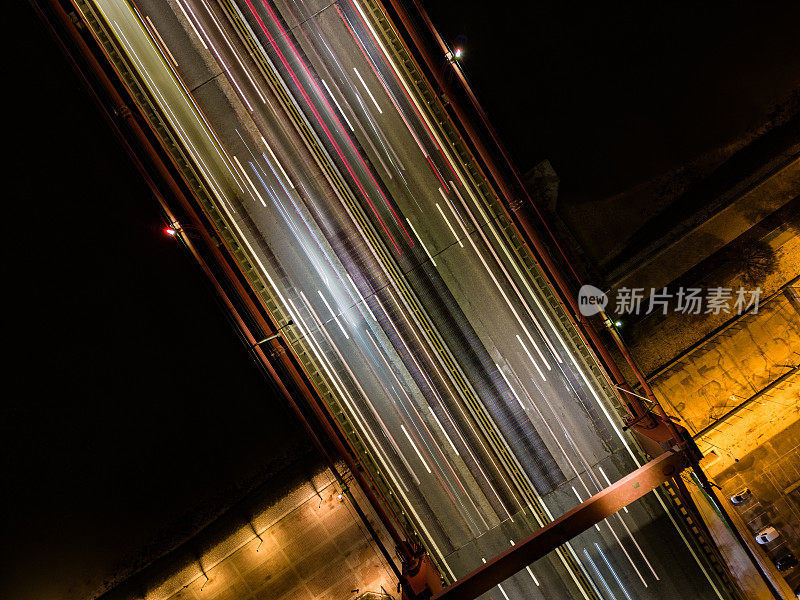 夜间里斯本主桥上的空中无人机天空视图镜头，有彩色的光迹