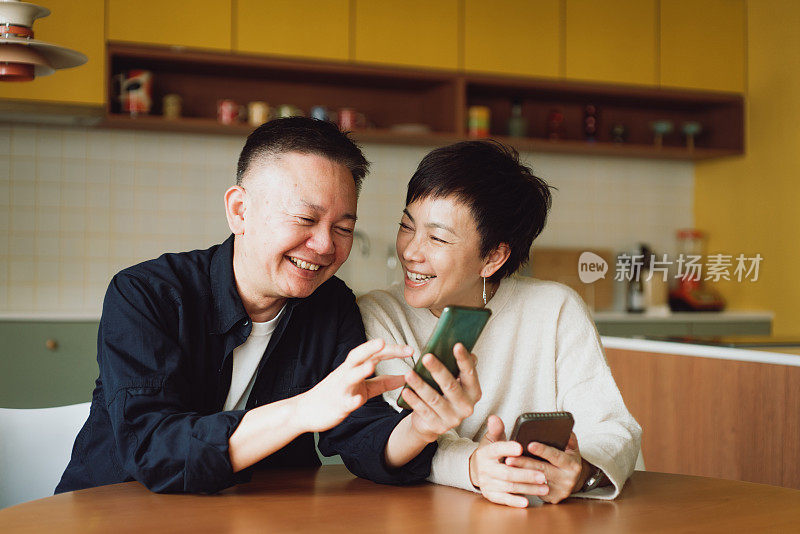 亚洲夫妇在家里使用智能手机