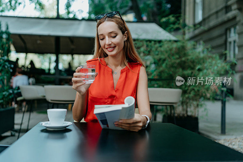 一个女人在咖啡馆里享受着她的咖啡，与她的书为伴，在完美的和谐中融合了阅读和啜饮的乐趣