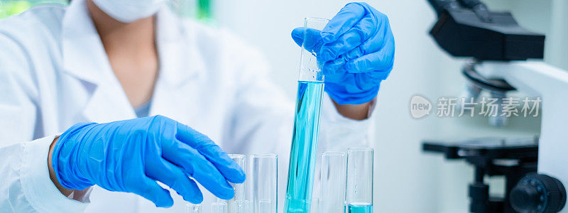 实验室里科学家手握蓝色化学物质的特写。检验生物技术和医学研究、检验、检验或发现的样品液质量的概念