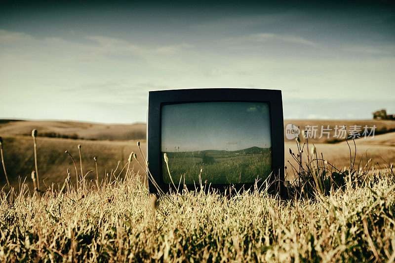 被遗弃在田野里的旧电视机。