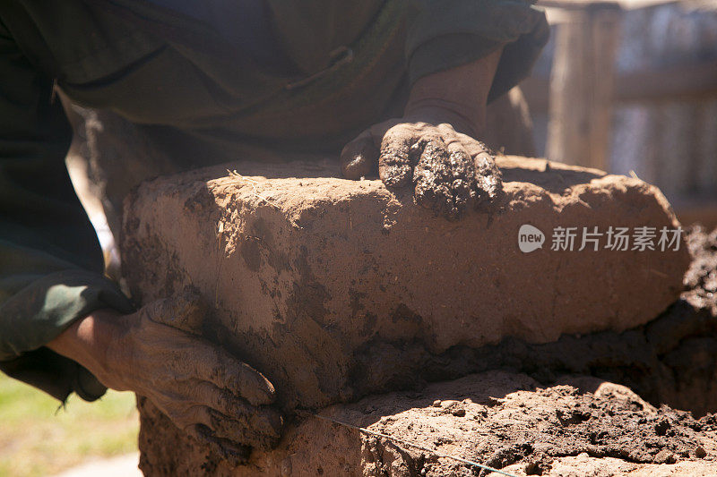 一个人用他的手用土砖和泥盖了一座土坯房。秘鲁的的喀喀湖的拉孔地区。