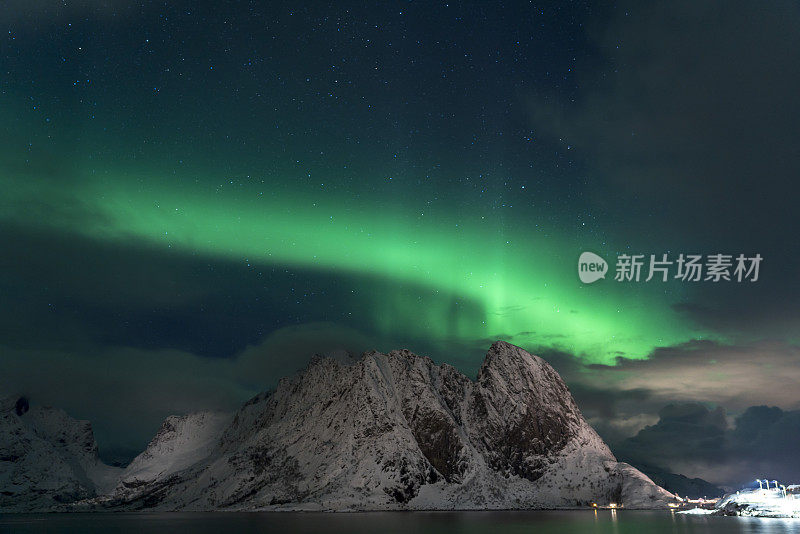 强烈的北极光在罗弗敦群岛的山脉后面和上空跳舞