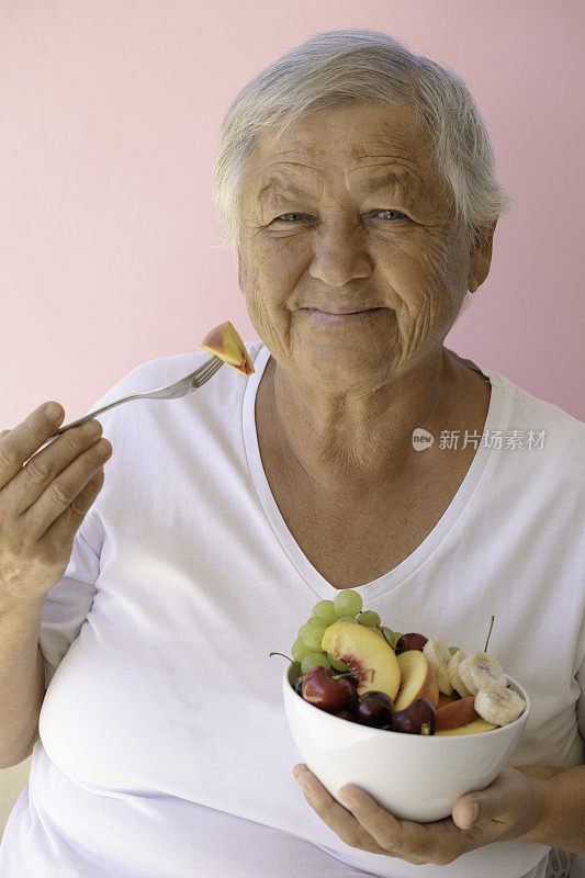吃水果沙拉的老妇人