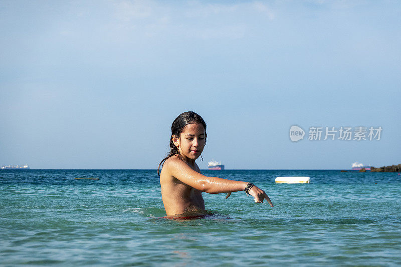 他用手在海里泼水。一个夏天的早晨。忒涅多斯岛。爱琴海北部，12岁的帅哥。长头发的