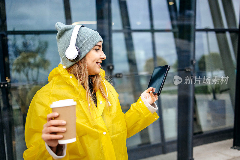 女人在下雨天穿着黄色雨衣去上班