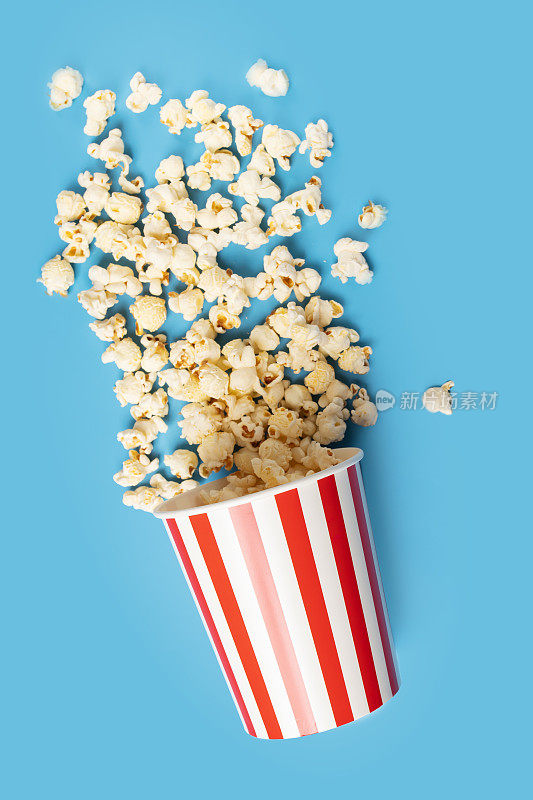 爆米花桶，经典脆的零食，电影院电影条纹盒，蓝色背景