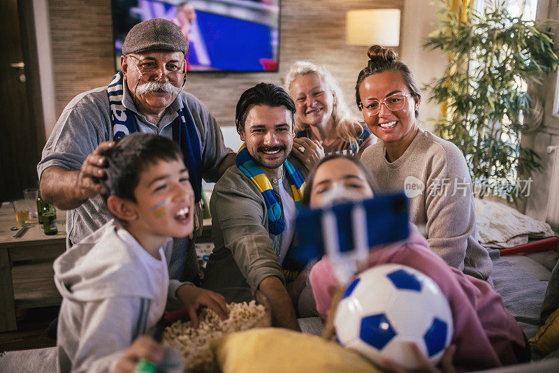 几代同堂的家庭一边看足球比赛一边自拍