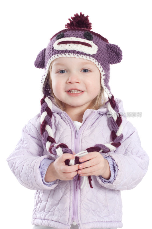 小女孩戴着紫色的冬帽和冬大衣