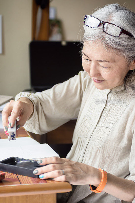 亚洲年长女性艺术家使用Suiteki和sudzuri