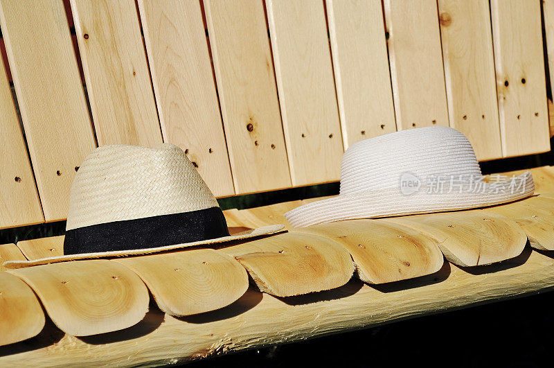 坐在长椅上休息。夏日的帽子放在木凳上。