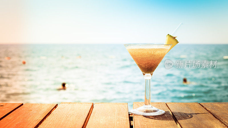 热带度假的概念。码头上的异国鸡尾酒。豪华度假背景。橙色鸡尾酒和海景