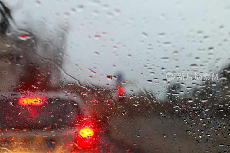 开车经过车流时，雨点落在挡风玻璃上