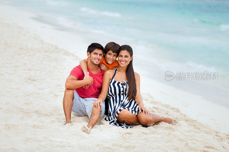 欢乐的一家人坐在海滩上