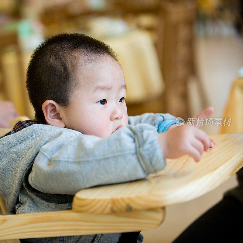 小男孩坐在儿童椅上