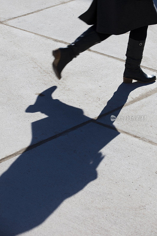 一个行走的女人的剪影和影子