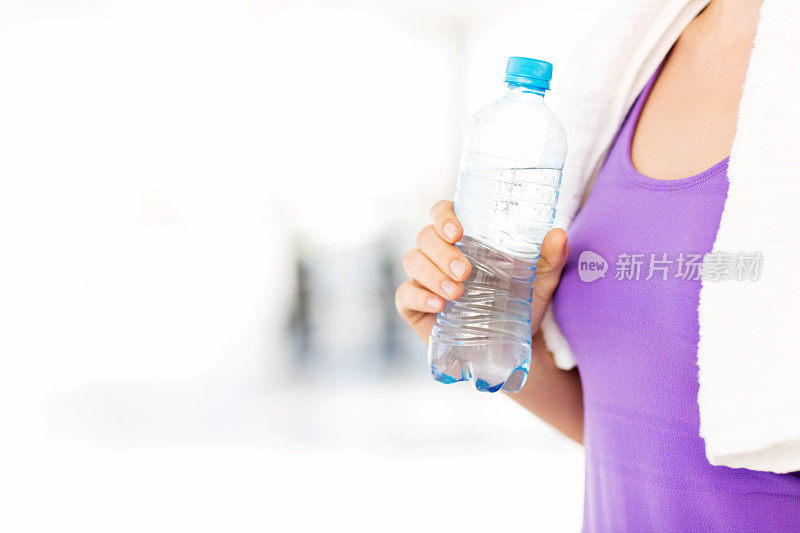 在健身房拿着水瓶的女人的特写